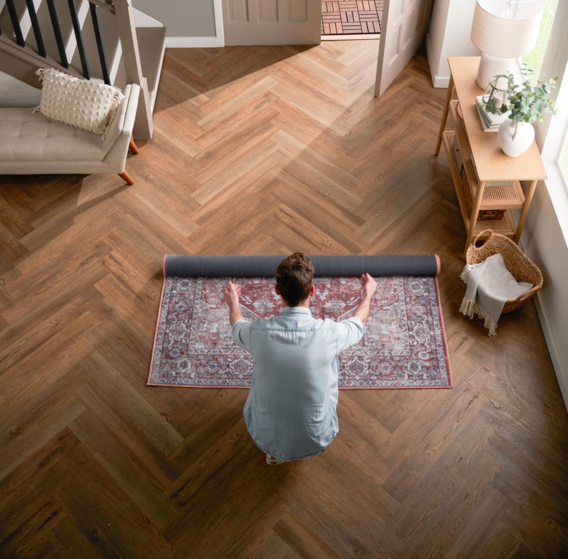 Image of a man rolling out a rug in the entryway