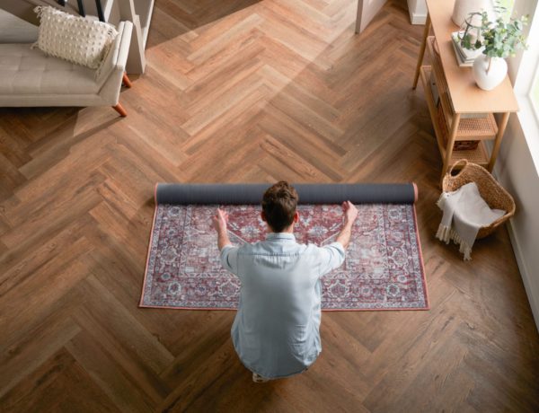 Image of a man rolling out a rug in the entryway